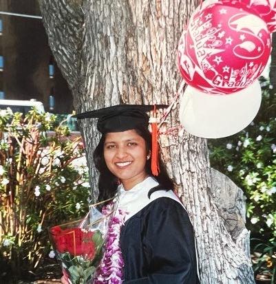 Seema, an Indian-American woman, posing in a graduation cap and gown