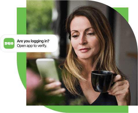 A woman looking at her mobile phone while receiving a Duo Push message about verifying her login attempt.