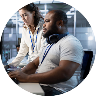 Two people looking at computer and working together on a task