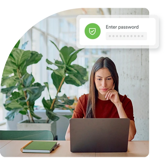 Person entering a password on a laptop confirmed by a green shield icon