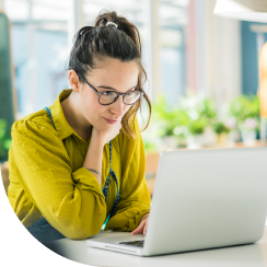 Lady wearing glasses looking at Laptop Screen