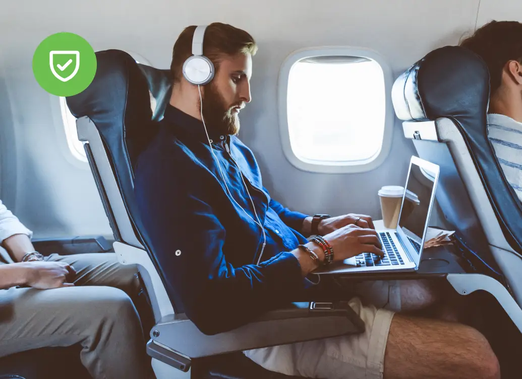 Professional using a laptop on an airplane, representing secure mobile and remote authentication for enterprise environments