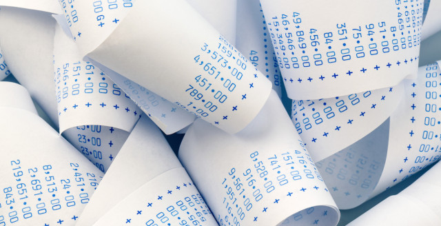 A massive pile of adding machine tape with huge numbers listed on it representing the cost of a data breach.