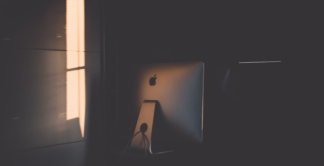An iMac monitor sits in a darkened room, waiting for someone to securely access its storage.