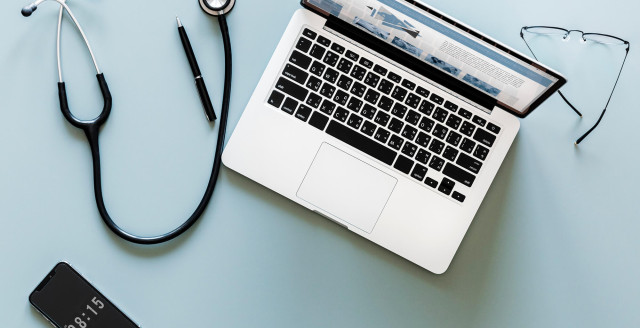 A doctor's stethoscope and a laptop with Duo Security