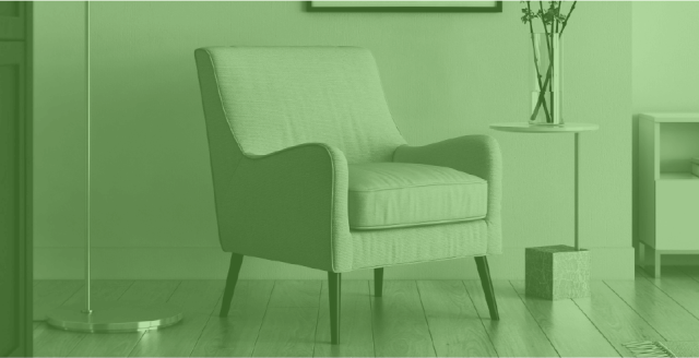 Stationary chair in a wood-floored room next to a end table with a vase of flowers. Entire image has a green overlay.