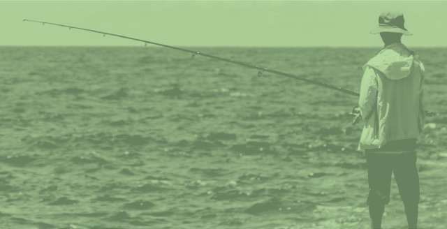 Man phishing in the ocean, overlaid with a color filter in Duo green