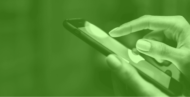 Image of woman's hands using a mobile device, colored green.