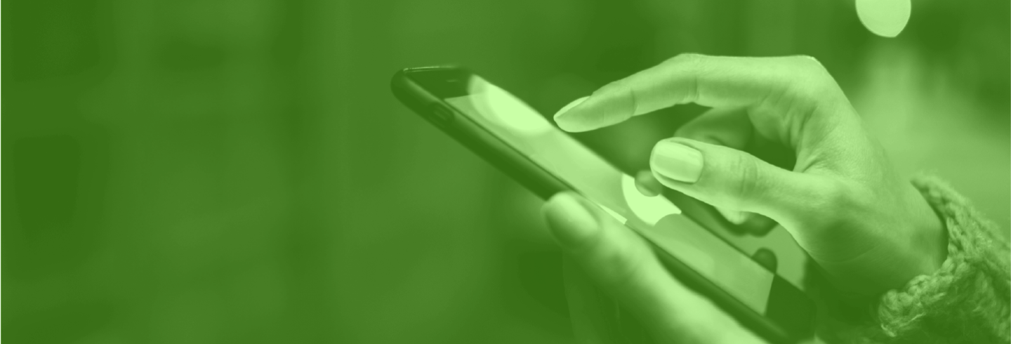Image of woman's hands using a mobile device, colored green.